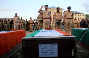 A senior police official paying tribute to the police personnel who were killed by suspected militants in their loot of a bank cash van, in Kulgam district of south Kashmir on Monday.(PTI) A senior police official paying tribute to the police personnel who were killed by suspected militants in their loot of a bank cash van, in Kulgam district of south Kashmir on Monday.(PTI)