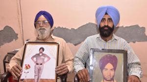 Ex-servicemen (left) Joginder Singh showing a picture during service and (right) Daljit Singh showing picture of his father Kashmir Singh who was martyr in Kargil, at Pandori Sidhwan village on Wednesday.(Sameer Sehgal/HT Photo)