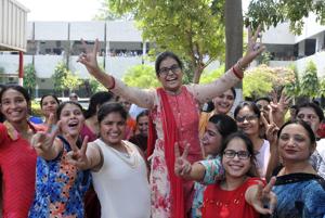 Amisha Arora , who bagged the first position in the state by securing 98.44% marks in the Senior Secondary Examination (Class 12) conducted by the Punjab School Education Board (PSEB), celebrates with friends and family at RS Model Senior Secondary School, Ludhiana.(Gurminder Singh/HT Photo)