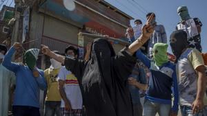 A burqa-clad Kashmiri woman along with masked protesters shout pro-freedom slogans during a protest in Srinagar on June 9, 2017.(AP Photo) A burqa-clad Kashmiri woman along with masked protesters shout pro-freedom slogans during a protest in Srinagar on June 9, 2017.(AP Photo)