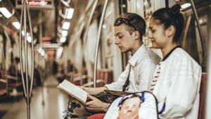 Youngsters read a book while travelling in a metro train.(Getty Images) Youngsters read a book while travelling in a metro train.(Getty Images)