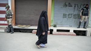 A woman walks past shops during a curfew in Srinagar on Friday, a day after Mohammad Ayub Pandith was beaten to death at Jama mosque.(AFP PHOTO) A woman walks past shops during a curfew in Srinagar on Friday, a day after Mohammad Ayub Pandith was beaten to death at Jama mosque.(AFP PHOTO)