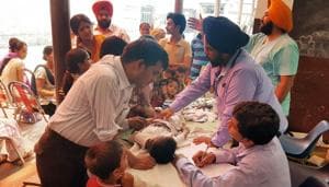 Doctors examining patients at a medical camp in Makkar Colony in Ludhiana on Sunday.(HT Photo)