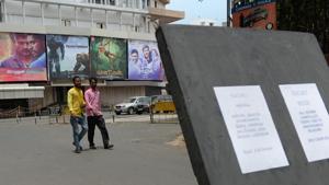 People walk past a closed cinema amid a shutdown called to protest the implementation of GST in Chennai.(AFP) People walk past a closed cinema amid a shutdown called to protest the implementation of GST in Chennai.(AFP)