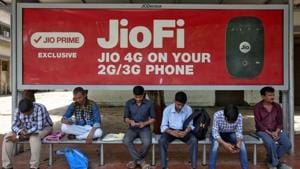 Commuters use their mobile phones as they wait at a bus stop with an advertisement of Reliance Industries' Jio telecoms unit, in Mumbai.(Reuters Photo) Commuters use their mobile phones as they wait at a bus stop with an advertisement of Reliance Industries' Jio telecoms unit, in Mumbai.(Reuters Photo)