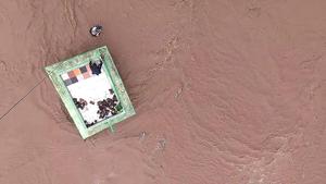 This official handout photograph shows an Indian Air Force (IAF) personnel after being lowered from an helicopter to help residents taking shelter atop a dargah surrounded by flood waters in Gujarat.(AFP Photo) This official handout photograph shows an Indian Air Force (IAF) personnel after being lowered from an helicopter to help residents taking shelter atop a dargah surrounded by flood waters in Gujarat.(AFP Photo)