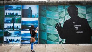 A woman takes pictures of the installation "Beyond The Wall" by German artist Stefan Roloff that is mounted on remnants of the former Berlin Wall.(AFP Photo) A woman takes pictures of the installation "Beyond The Wall" by German artist Stefan Roloff that is mounted on remnants of the former Berlin Wall.(AFP Photo)