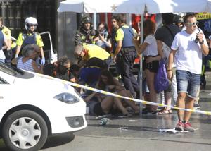 Injured people are treated after a white van ploughed through a crowd in Barcelona on August 17, 2017.(AP) Injured people are treated after a white van ploughed through a crowd in Barcelona on August 17, 2017.(AP)