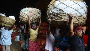 This file photo taken on February 28, 2017 showslabourers carrying baskets of vegetables at the main wholesale vegetable market in Kolkata. India's growth slumped to 5.7 percent in the first quarter of the financial year, official data showed August 31, below predictions as a controversial banknote ban dragged further on the economy.(AFP Photo) This file photo taken on February 28, 2017 showslabourers carrying baskets of vegetables at the main wholesale vegetable market in Kolkata. India's growth slumped to 5.7 percent in the first quarter of the financial year, official data showed August 31, below predictions as a controversial banknote ban dragged further on the economy.(AFP Photo)