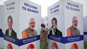 A worker cleans a hoarding featuring Prime Minister Narendra Modi and his Japanese counterpart Shinzo Abe ahead of Abe's visit, in Ahmedabad on September 10.(REUTERS)
