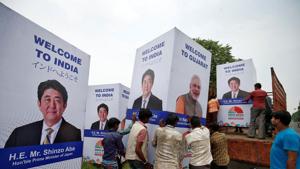 Workers carry a hoarding featuring Prime Minister Narendra Modi and his Japanese counterpart Shinzo Abe to load it onto a truck ahead of Abe's visit, in Ahmedabad on September 10.(REUTERS) Workers carry a hoarding featuring Prime Minister Narendra Modi and his Japanese counterpart Shinzo Abe to load it onto a truck ahead of Abe's visit, in Ahmedabad on September 10.(REUTERS)
