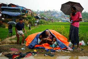 Rohingya refugees sit on the roadside as they take shelter from the rain in Cox's Bazar, Bangladesh on September 17, 2017.(Reuters) Rohingya refugees sit on the roadside as they take shelter from the rain in Cox's Bazar, Bangladesh on September 17, 2017.(Reuters)