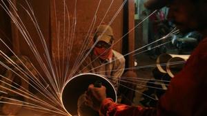A worker cuts metal inside a workshop manufacturing metal pipes in Mumbai. India’s manufacturing industry can largely be divided into a limited number of large-sized firms and a preponderance of small, household enterprises, with a gaping hole in the middle.(Reuters File Photo) A worker cuts metal inside a workshop manufacturing metal pipes in Mumbai. India’s manufacturing industry can largely be divided into a limited number of large-sized firms and a preponderance of small, household enterprises, with a gaping hole in the middle.(Reuters File Photo)