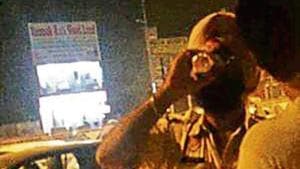 A video grab showing a constable consuming liquor near a petrol pump in Amritsar on Monday.(HT Photo) A video grab showing a constable consuming liquor near a petrol pump in Amritsar on Monday.(HT Photo)