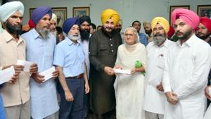 Punjab local bodies minister Navjot Sing Sidhu giving compensation to the aggrieved farmers at Bachat Bhawan, in Amritsar on Wednesday.(Sameer Sehgal/HT) Punjab local bodies minister Navjot Sing Sidhu giving compensation to the aggrieved farmers at Bachat Bhawan, in Amritsar on Wednesday.(Sameer Sehgal/HT)