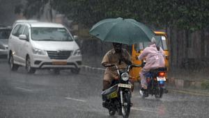 A man rides a moped in the rain in Chennai on Monday.(AFP) A man rides a moped in the rain in Chennai on Monday.(AFP)