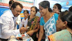 A bank employee (L) explains to visitors about account transactions from a mobile phone during a Digi Dhan Mela, held to promote digital payment, in Hyderabad on January 18, 2017.(AFP file photo) A bank employee (L) explains to visitors about account transactions from a mobile phone during a Digi Dhan Mela, held to promote digital payment, in Hyderabad on January 18, 2017.(AFP file photo)