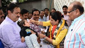 Suman Sharma , chairperson, Rajasthan Women’s Commission and health minister Kalicharan Saraf administer Vitamin A dose to a child in Jaipur on Wednesday.(HT Photo)