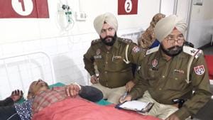 Punjab police personnel with the injured Gurpreet Singh in civil hospital in Mansa.(HT Photo)