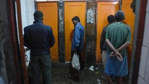 People wait outside a toilet at the Lahori Gate night shelter in New Delhi on Saturday.(Ravi Choudhary/HT PHOTO)