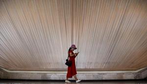 A woman looks at her phone as she walks inside an exhibition centre in Shanghai.(AFP File Photo) A woman looks at her phone as she walks inside an exhibition centre in Shanghai.(AFP File Photo)