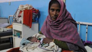 Munni, holding her newborn baby girl, whom she had to deliver without medical support outside the emergency ward.(Parveen Kumar/HT Photo)