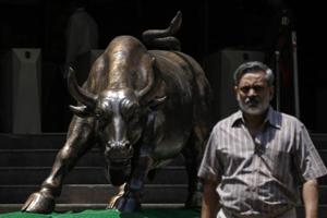 A bronze bull sculpture is seen as an employee walks out of the Bombay Stock Exchange (BSE) building in Mumbai.(Reuters File Photo) A bronze bull sculpture is seen as an employee walks out of the Bombay Stock Exchange (BSE) building in Mumbai.(Reuters File Photo)