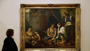 A woman looks at the painting Femmes d'Alger dans leur appartement at the exhibition A woman looks at the painting Femmes d'Alger dans leur appartement at the exhibition