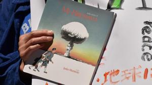 An anti-nuclear protester holds best-selling children's author and Hiroshima bombing survivor Junko Morimoto's book, ‘My Hiroshima’, at a rally outside the Australian government offices in Sydney on February 5, 2018.(AFP Photo) An anti-nuclear protester holds best-selling children's author and Hiroshima bombing survivor Junko Morimoto's book, ‘My Hiroshima’, at a rally outside the Australian government offices in Sydney on February 5, 2018.(AFP Photo)