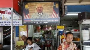Passerby walks in front of a live broadcast of an announcement by Malaysian Prime Minister Najib Razak at a restaurant in Kuala Lumpur, Malaysia, on April 6, 2018.(AP) Passerby walks in front of a live broadcast of an announcement by Malaysian Prime Minister Najib Razak at a restaurant in Kuala Lumpur, Malaysia, on April 6, 2018.(AP)
