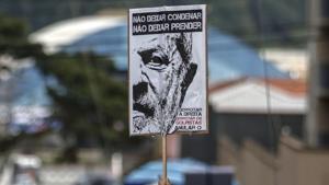 A supporter of Brazilian former president Luiz Inacio Lula da Silva holds a sign with his image during a Catholic Mass in memory of Lula's late wife Marisa Leticia in the Metallurgical Union, in Sao Bernardo do Campo, Brazil, after judge Sergio Moro issued a warrant to send Lula to prison, on April 7, 2018.(AFP) A supporter of Brazilian former president Luiz Inacio Lula da Silva holds a sign with his image during a Catholic Mass in memory of Lula's late wife Marisa Leticia in the Metallurgical Union, in Sao Bernardo do Campo, Brazil, after judge Sergio Moro issued a warrant to send Lula to prison, on April 7, 2018.(AFP)