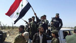 Syrian police units wave their national flag as they enter the town of Douma, site of a suspected chemical weapons attack and the last rebel town in the eastern Ghouta, near Damascus, Syria, on Saturday.(AP) Syrian police units wave their national flag as they enter the town of Douma, site of a suspected chemical weapons attack and the last rebel town in the eastern Ghouta, near Damascus, Syria, on Saturday.(AP)