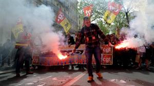 A protester hold flares during a march called " Stop Macron!" on April 14, 2018 in Marseille, southern France, to protest against planned reforms of the French government.(AFP) A protester hold flares during a march called " Stop Macron!" on April 14, 2018 in Marseille, southern France, to protest against planned reforms of the French government.(AFP)