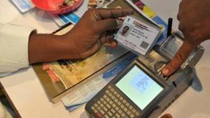 An Indian visitor gives a thumb impression to withdraw money from his bank account with his Aadhaar or Unique Identification (UID) card.(AFP FIle Photo)