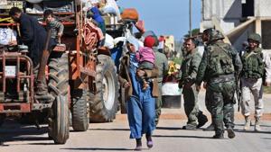 Displaced Syrian families arrive at a checkpoint manned by Syrian soldiers and Russian forces allied with the Syrian regime at the Abu al-Duhur crossing, as they return from rebel-held areas in Syria's northern Idlib province to their villages in government controlled territory in Idlib on April 4, 2018.(AFP) Displaced Syrian families arrive at a checkpoint manned by Syrian soldiers and Russian forces allied with the Syrian regime at the Abu al-Duhur crossing, as they return from rebel-held areas in Syria's northern Idlib province to their villages in government controlled territory in Idlib on April 4, 2018.(AFP)