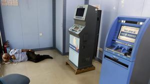 A security guard sleeps near an 'out of service' ATM machine in Ahmedabad on Tuesday.(PTI Photo) A security guard sleeps near an 'out of service' ATM machine in Ahmedabad on Tuesday.(PTI Photo)
