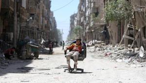 A boy sits on a chair along a damaged street at the city of Douma in Damascus, Syria April 16, 2018.(REUTERS Photo) A boy sits on a chair along a damaged street at the city of Douma in Damascus, Syria April 16, 2018.(REUTERS Photo)