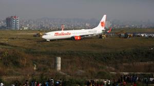 People gather near an aircraft belonging to Malindo Air that skidded off the runway during take off last night at Tribhuvan International Airport in Kathmandu, Nepal.(Reuters Photo) People gather near an aircraft belonging to Malindo Air that skidded off the runway during take off last night at Tribhuvan International Airport in Kathmandu, Nepal.(Reuters Photo)