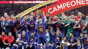 Barcelona's Andres Iniesta, center, holds up the trophy after winning the Copa del Rey final soccer match between Barcelona and Sevilla.(AP) Barcelona's Andres Iniesta, center, holds up the trophy after winning the Copa del Rey final soccer match between Barcelona and Sevilla.(AP)