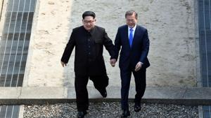 North Korean leader Kim Jong Un, left, and South Korean President Moon Jae-in cross the military demarcation line at the border village of Panmunjom in Demilitarized Zone on Friday, on Friday.(AP Photo) North Korean leader Kim Jong Un, left, and South Korean President Moon Jae-in cross the military demarcation line at the border village of Panmunjom in Demilitarized Zone on Friday, on Friday.(AP Photo)