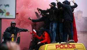 In this April 24, 2018 file photo, football fans stand on top of a police van amid smoke from flares outside the stadium before the UEFA Champions League semi-final first leg match between Liverpool FC and AS Roma at Anfield. Off-pitch tensions are high ahead of the second leg in Rome as Liverpool supporter Sean Cox lies in a coma after being attacked before last week’s match. Two Roma supporters were arrested on suspicion of attempted murder.(AP) In this April 24, 2018 file photo, football fans stand on top of a police van amid smoke from flares outside the stadium before the UEFA Champions League semi-final first leg match between Liverpool FC and AS Roma at Anfield. Off-pitch tensions are high ahead of the second leg in Rome as Liverpool supporter Sean Cox lies in a coma after being attacked before last week’s match. Two Roma supporters were arrested on suspicion of attempted murder.(AP)
