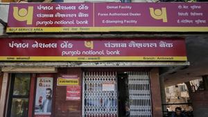 A man reads a newspaper outside a branch of Punjab National Bank in Ahmedabad.(REUTERS) A man reads a newspaper outside a branch of Punjab National Bank in Ahmedabad.(REUTERS)
