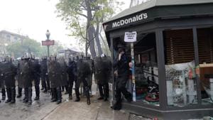CRS riot police officials stand next to a damaged McDonalds resteraunt during a demonstration on the sidelines of a march for the annual May Day workers' rally in Paris on May 1, 2018.(AFP) CRS riot police officials stand next to a damaged McDonalds resteraunt during a demonstration on the sidelines of a march for the annual May Day workers' rally in Paris on May 1, 2018.(AFP)