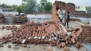 Residents look at a wall damaged by high winds during a major dust storm in Agra district.(AFP) Residents look at a wall damaged by high winds during a major dust storm in Agra district.(AFP)
