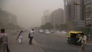 In this May 2 photo, people cross a road, enveloped by dust rising from a storm in New Delhi,(AP) In this May 2 photo, people cross a road, enveloped by dust rising from a storm in New Delhi,(AP)