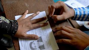 An election official puts indeliable ink on the finger of a voter before she casts her ballot in the Karnataka assembly elections at a polling station in Bangalore on May 12, 2018.(AFP Photo) An election official puts indeliable ink on the finger of a voter before she casts her ballot in the Karnataka assembly elections at a polling station in Bangalore on May 12, 2018.(AFP Photo)