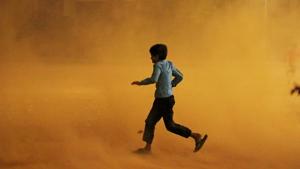 A boy runs for cover during a dust storm in New Delhi on Sunday. The Met office has forecast more storms till Tuesday.(Reuters photo) A boy runs for cover during a dust storm in New Delhi on Sunday. The Met office has forecast more storms till Tuesday.(Reuters photo)