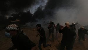 Palestinian demonstrators run for cover during a protest against the US embassy’s relocation to Jerusalem at the Israel-Gaza border in the southern Gaza Strip on Monday.(REUTERS Photo) Palestinian demonstrators run for cover during a protest against the US embassy’s relocation to Jerusalem at the Israel-Gaza border in the southern Gaza Strip on Monday.(REUTERS Photo)