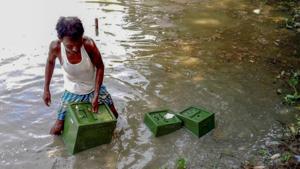 A man collects ballot boxes from a pond thrown by some unknown people during panchayat elections in West Bengal, in Memari of Burdwan district on Monday.(PTI photo) A man collects ballot boxes from a pond thrown by some unknown people during panchayat elections in West Bengal, in Memari of Burdwan district on Monday.(PTI photo)
