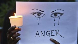 A woman holds a candle and placard seeking an end to sexual violence against women.(AP File Photo) A woman holds a candle and placard seeking an end to sexual violence against women.(AP File Photo)